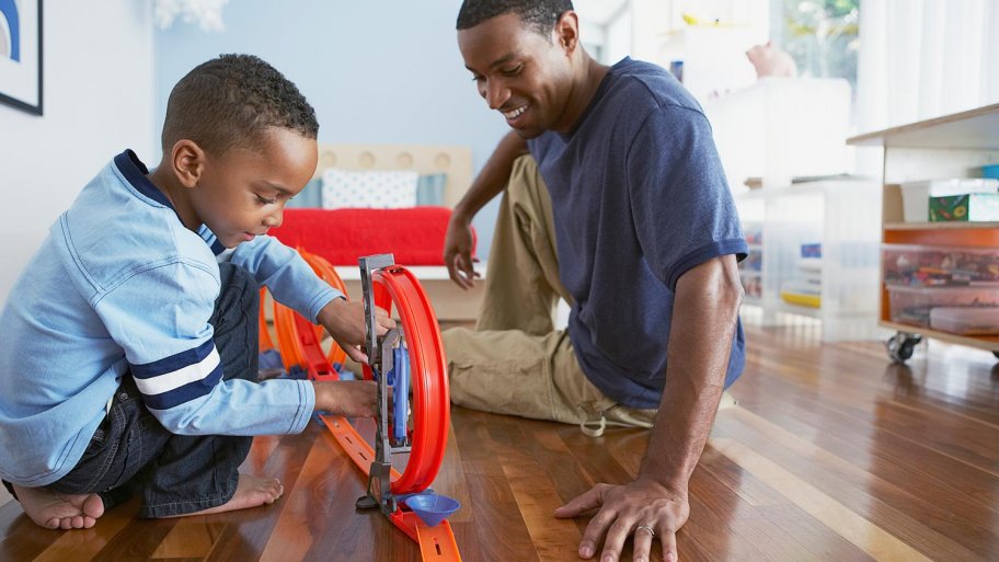 Father playing with son on hardwood