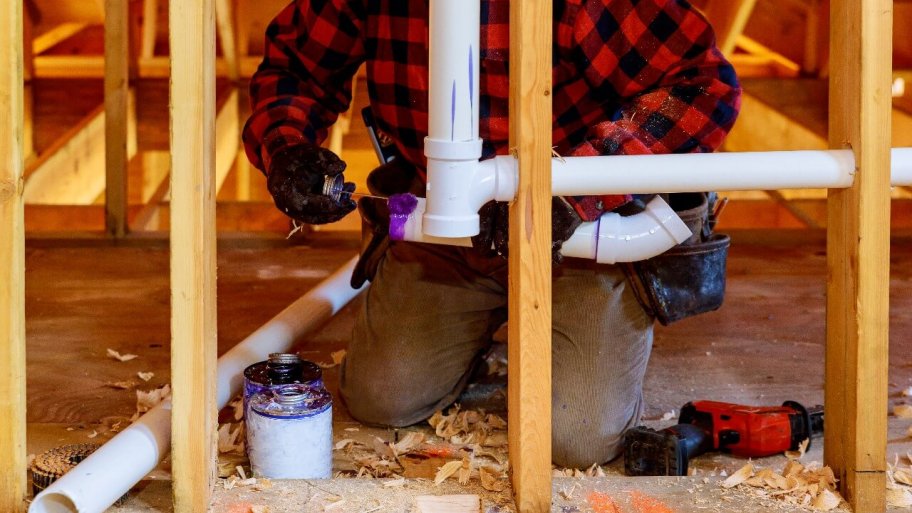 plumber installs pipes in a home