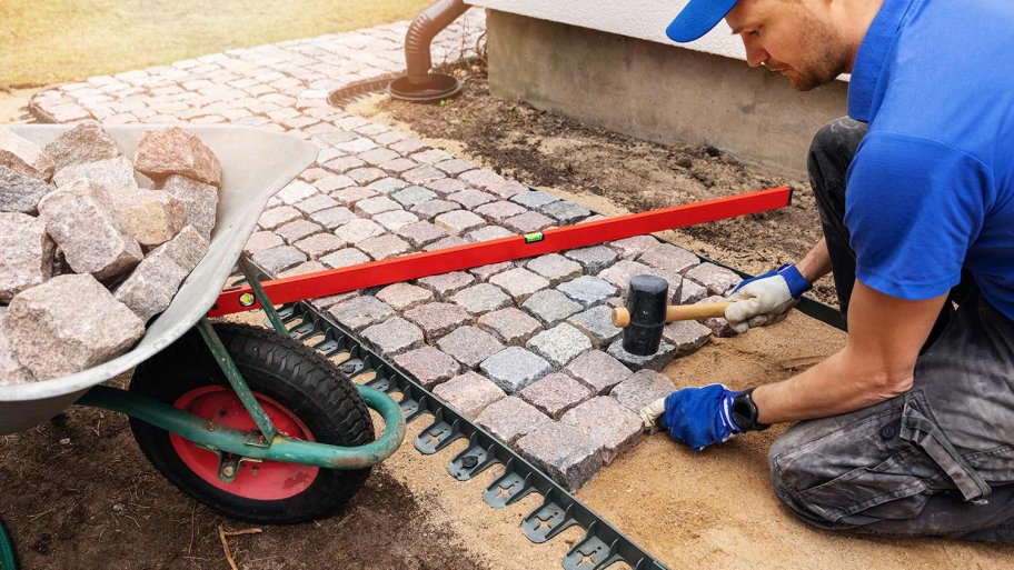 Professional paver laying sidewalk