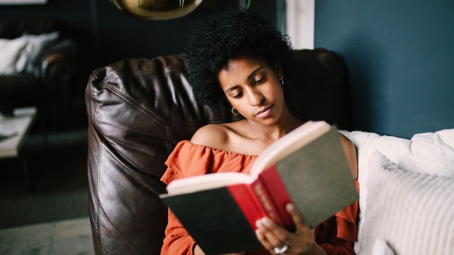 woman reading book in chair