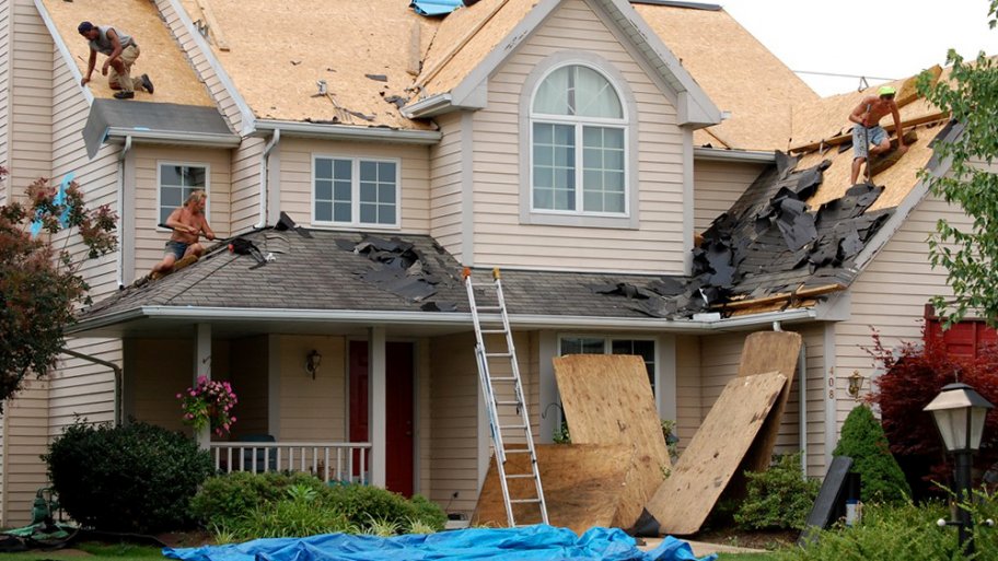 roofers tearing off old asphalt shingle roof