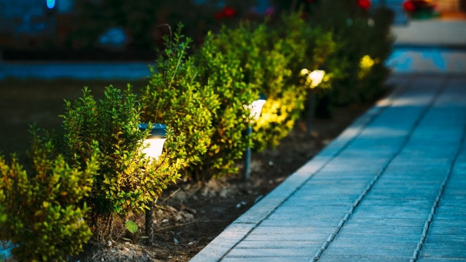 solar-powered torches along walkway in front of home at night