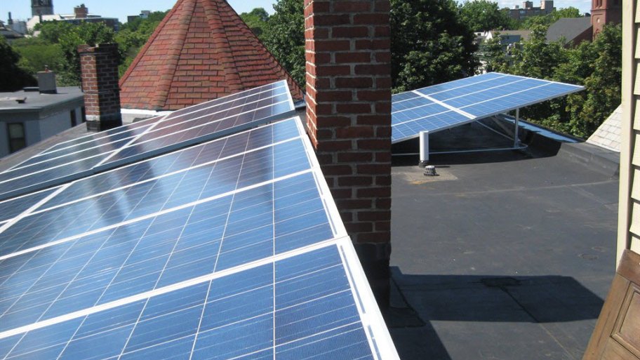 Solar panels on a rooftop with tall brick chimney