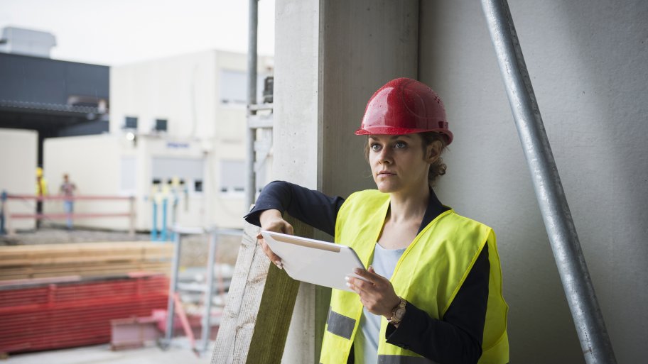 a strucutral engineer on a job site. she holds a tablet