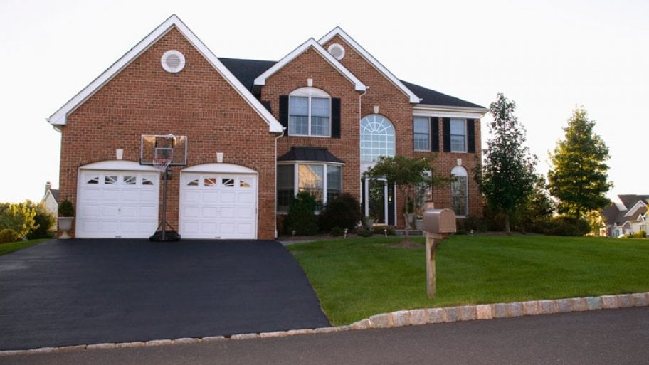 suburban home with red brick and asphalt driveway