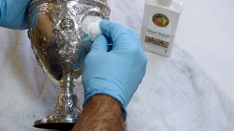 Hands polishing a silver goblet
