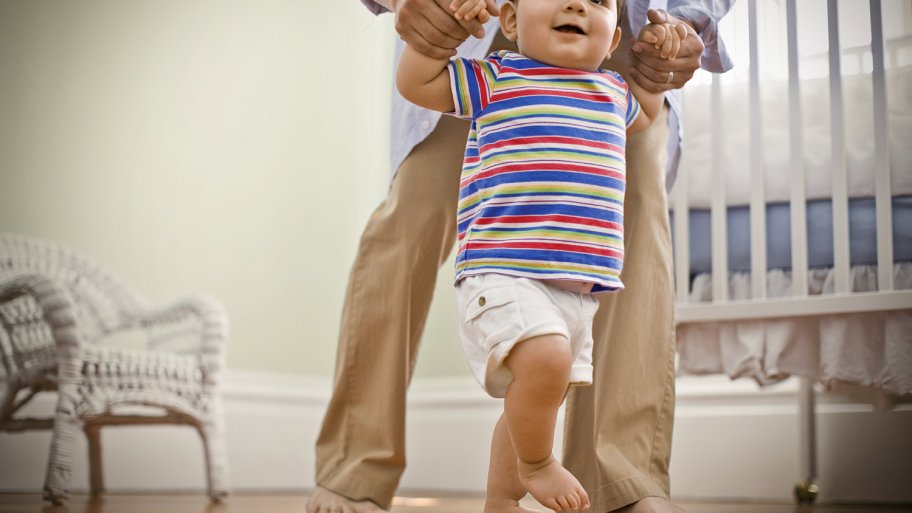 Toddler being helped across hardwood floor Toddler being helped across hardwood floor
