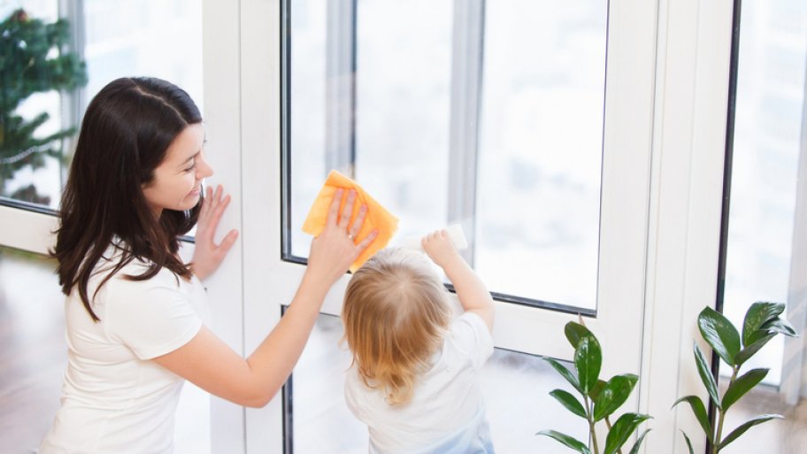 Mother and child cleaning window together