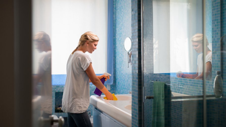 Woman cleaning her blue bathroom