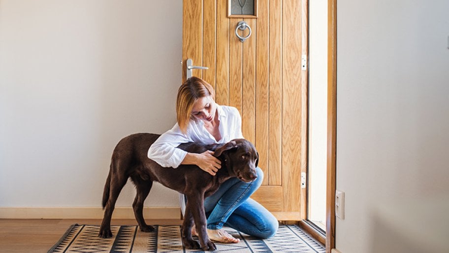 Woman pets dog by front door
