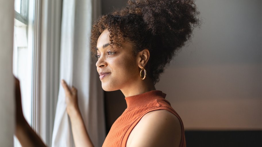 woman at home looking out the window