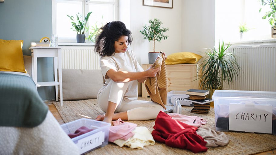 Young woman sorting her wardrobe clothes