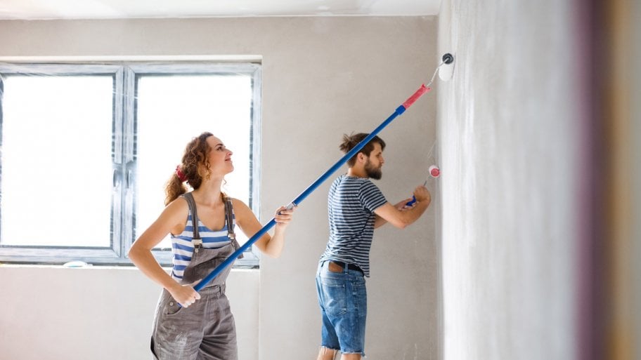 A young couple paints a wall