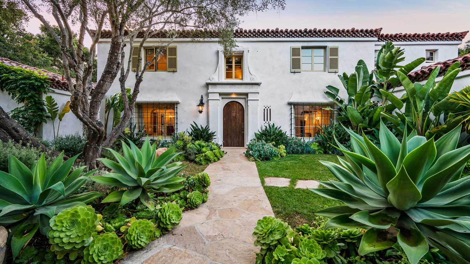 A home with a garden and landscaping on either side
