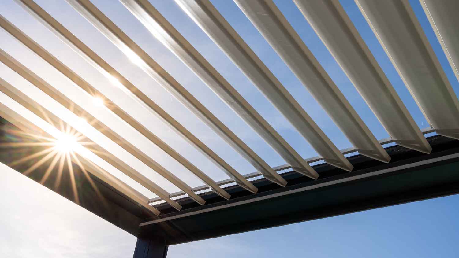 Sun rays getting through a metallic smart pergola