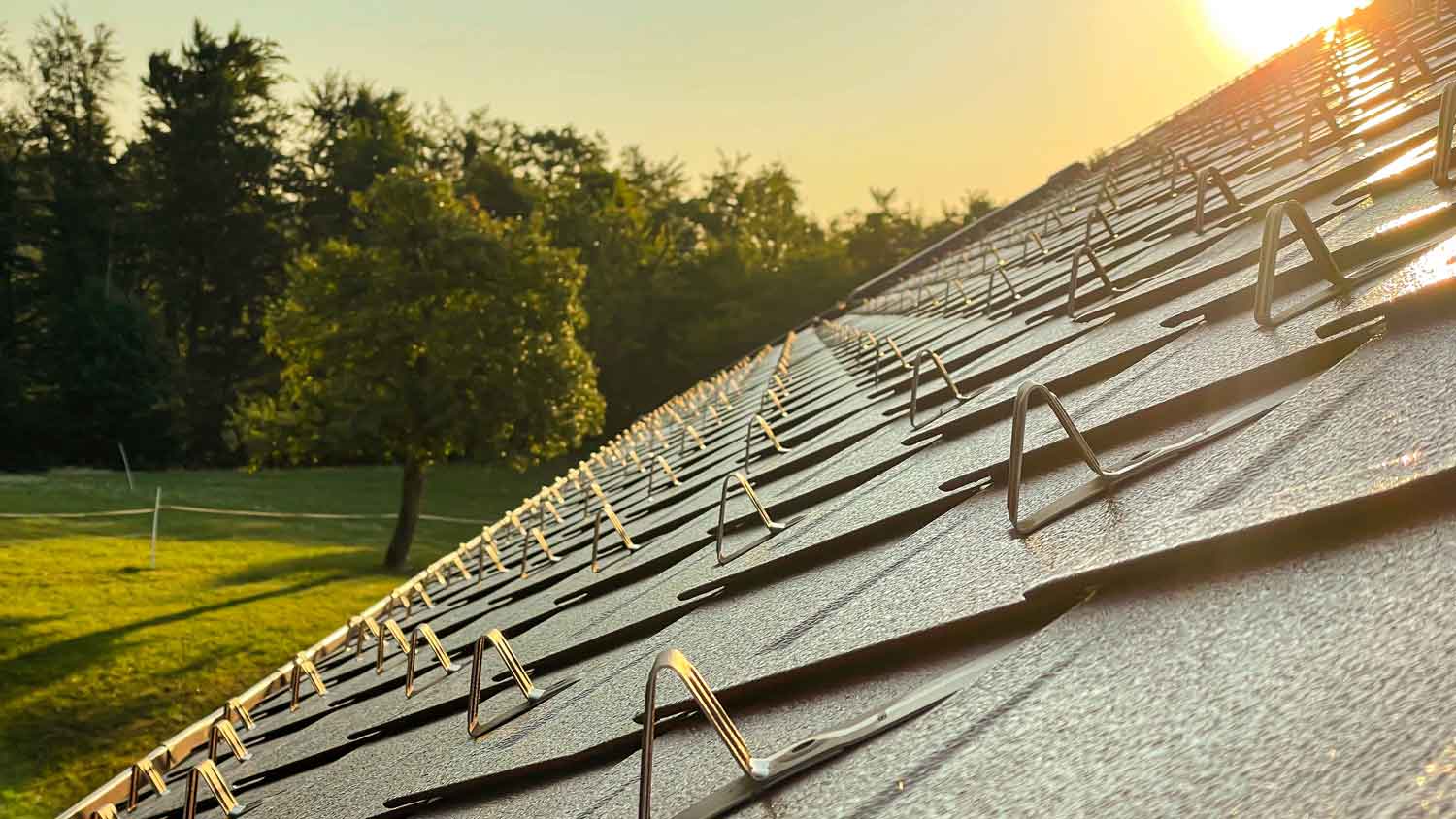 Sunset illuminating snow guards on a roof