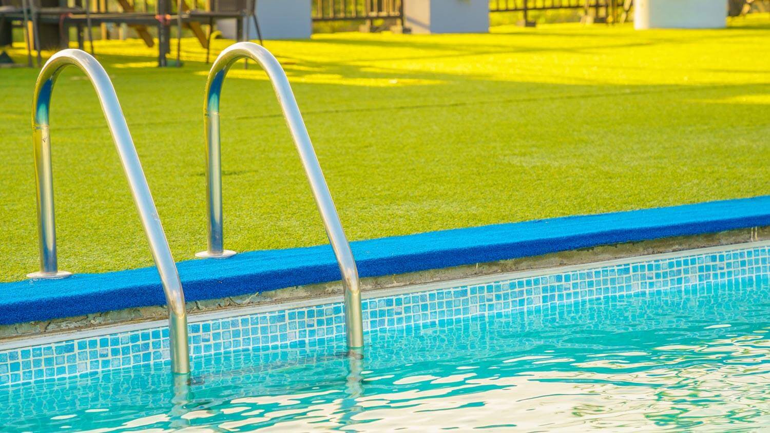 Close-up of a swimming pool with artificial turf surrounding it