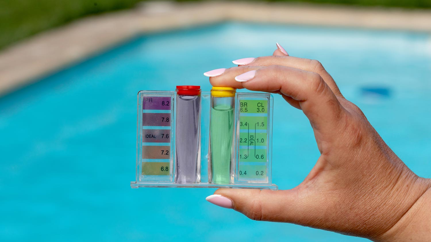 A person holding a pool water pH testing kit.