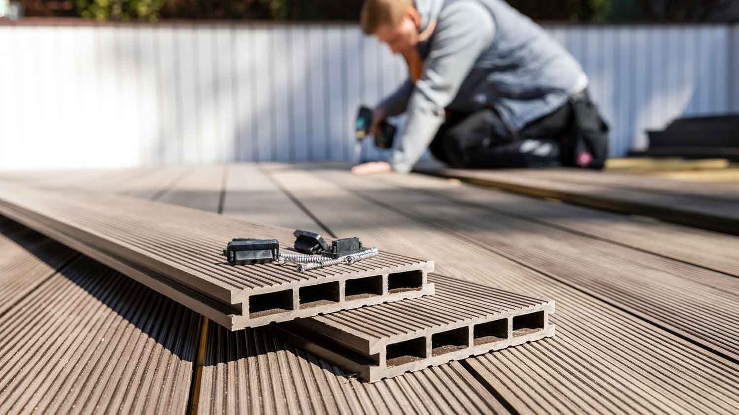 Worker installing synthetic decking