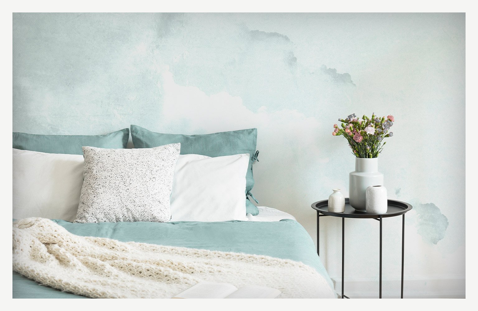 teal watercolor wall painting above bed and side table