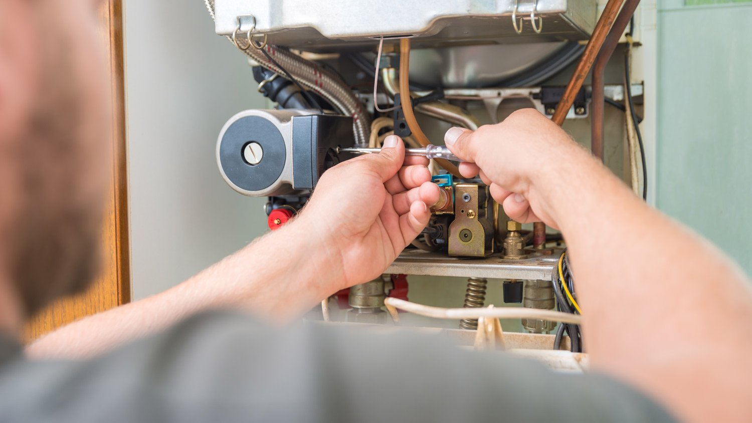 A technician checking a gas furnace