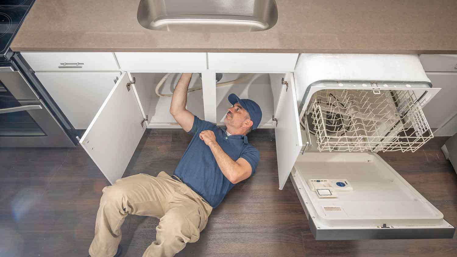 Appliance technician installing dishwasher hose