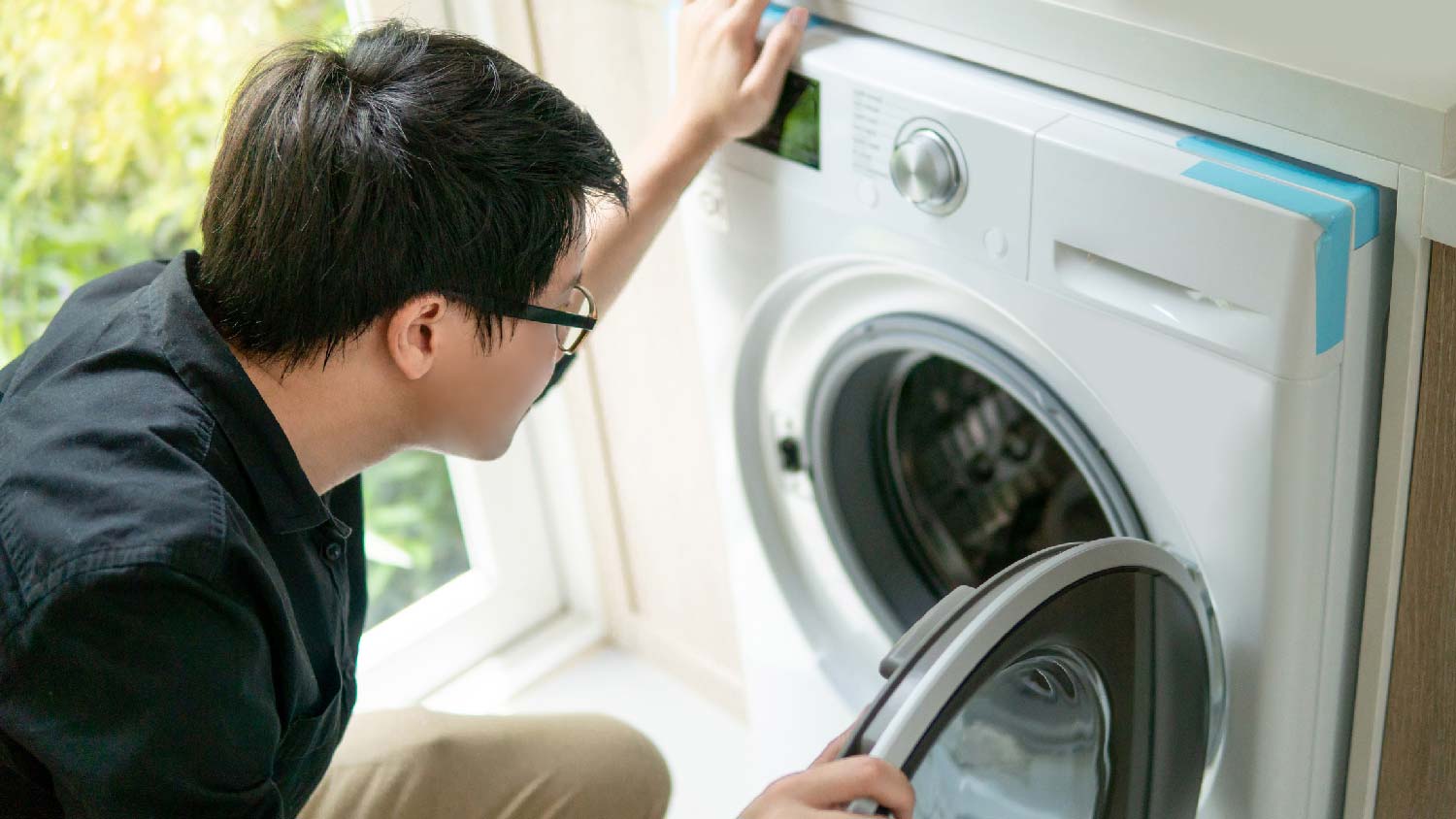 A technician installing a washer