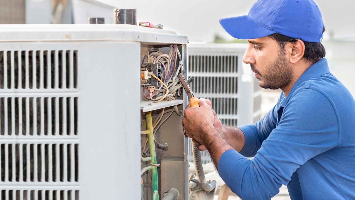 Technician repairing hvac unit outside of the house