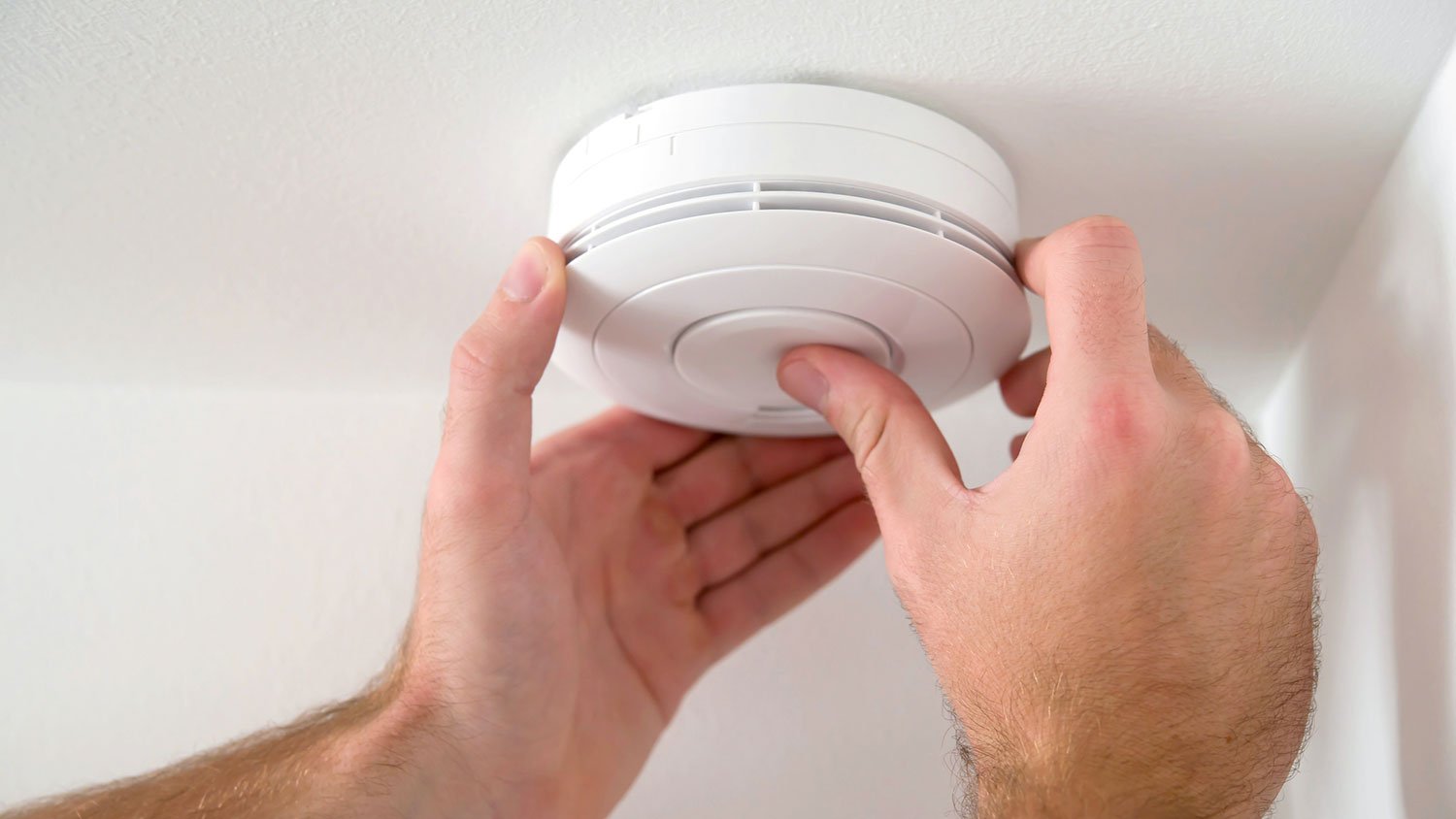 Closeup of a man testing smoke detector