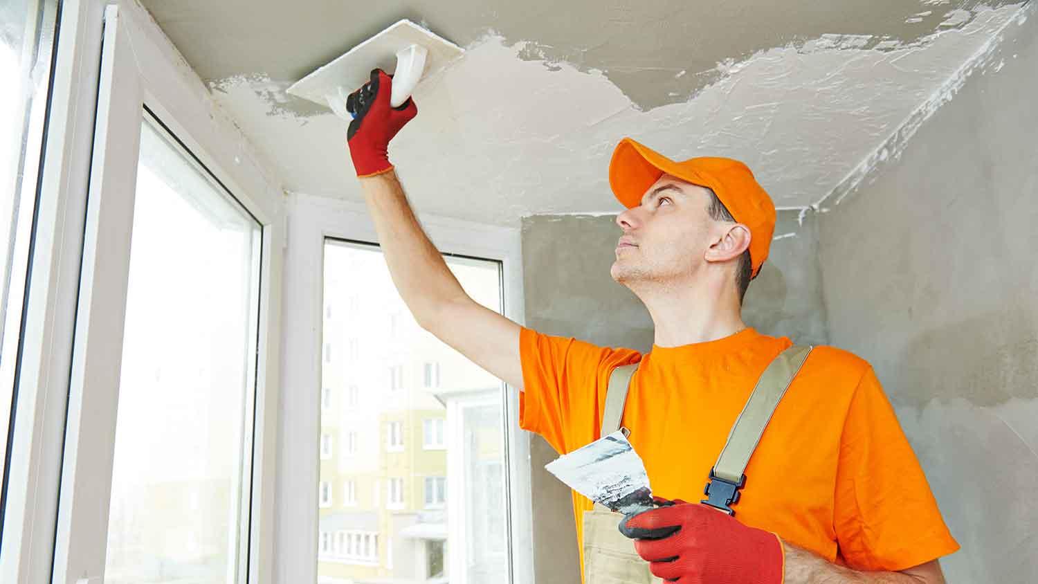 Professional using a trowel to apply textured ceiling