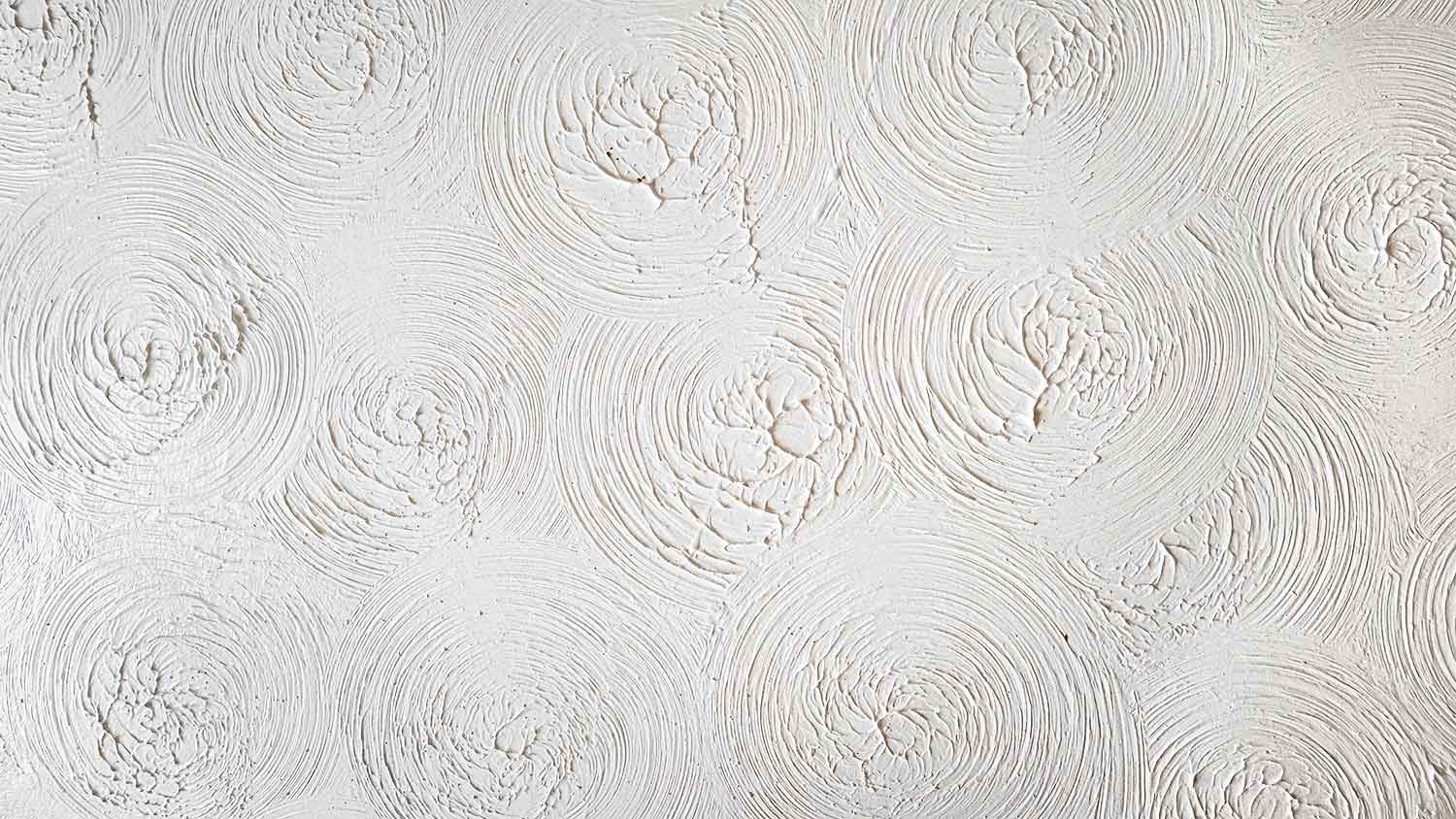 Closeup of a white textured ceiling with a swirls pattern