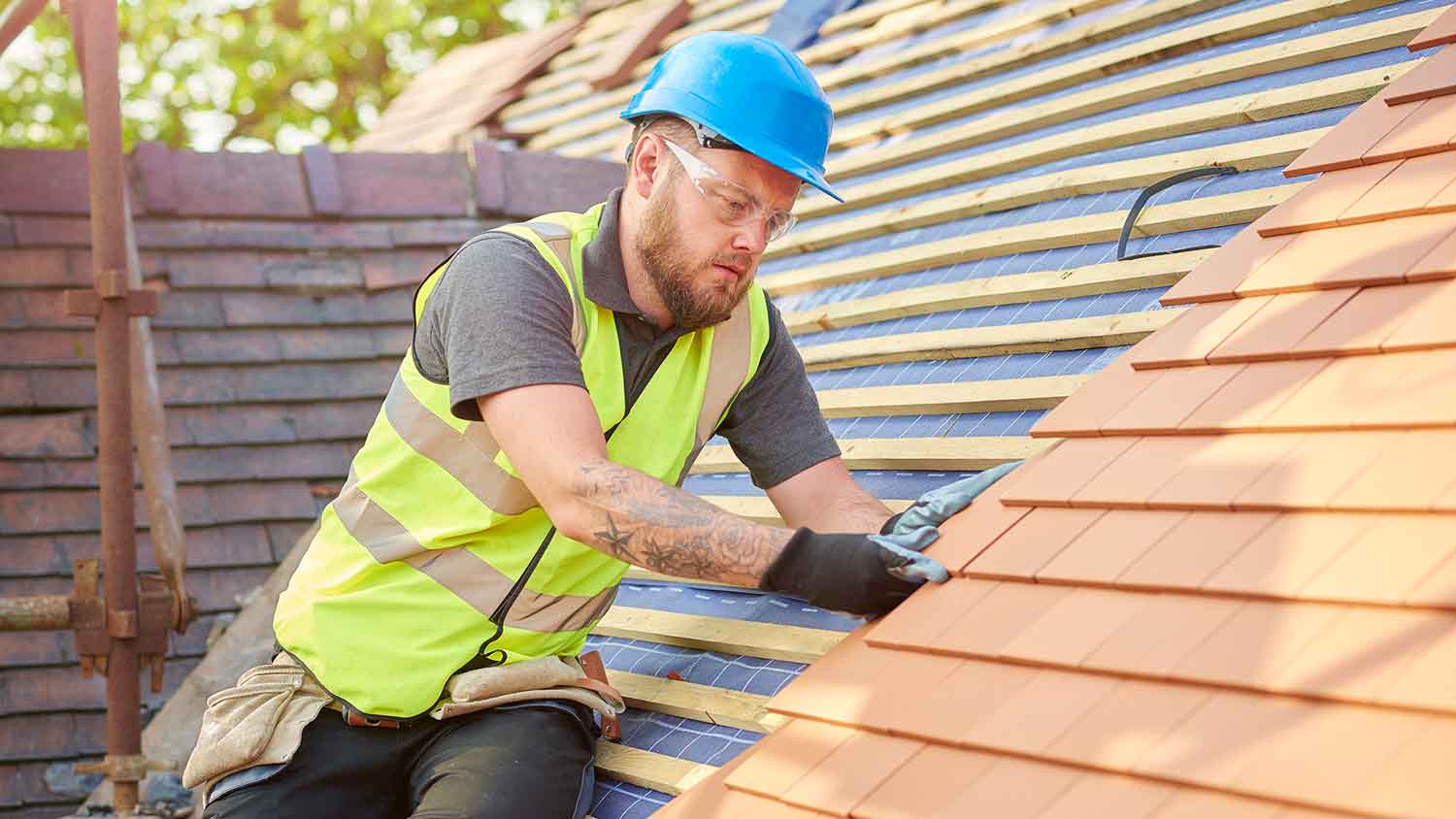 Contractor installing clay terracotta tile on the roof