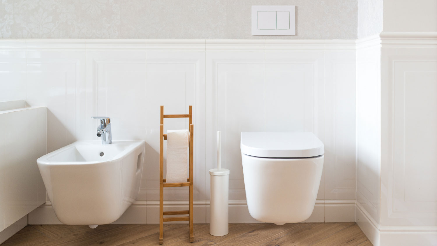 A toilet next to a bidet in a bathroom