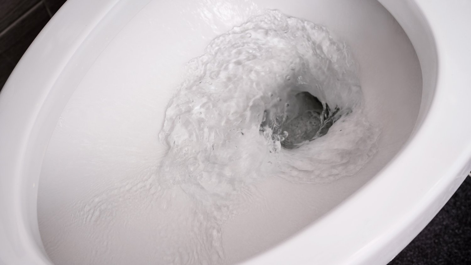 Close up flushing water in toilet bowl