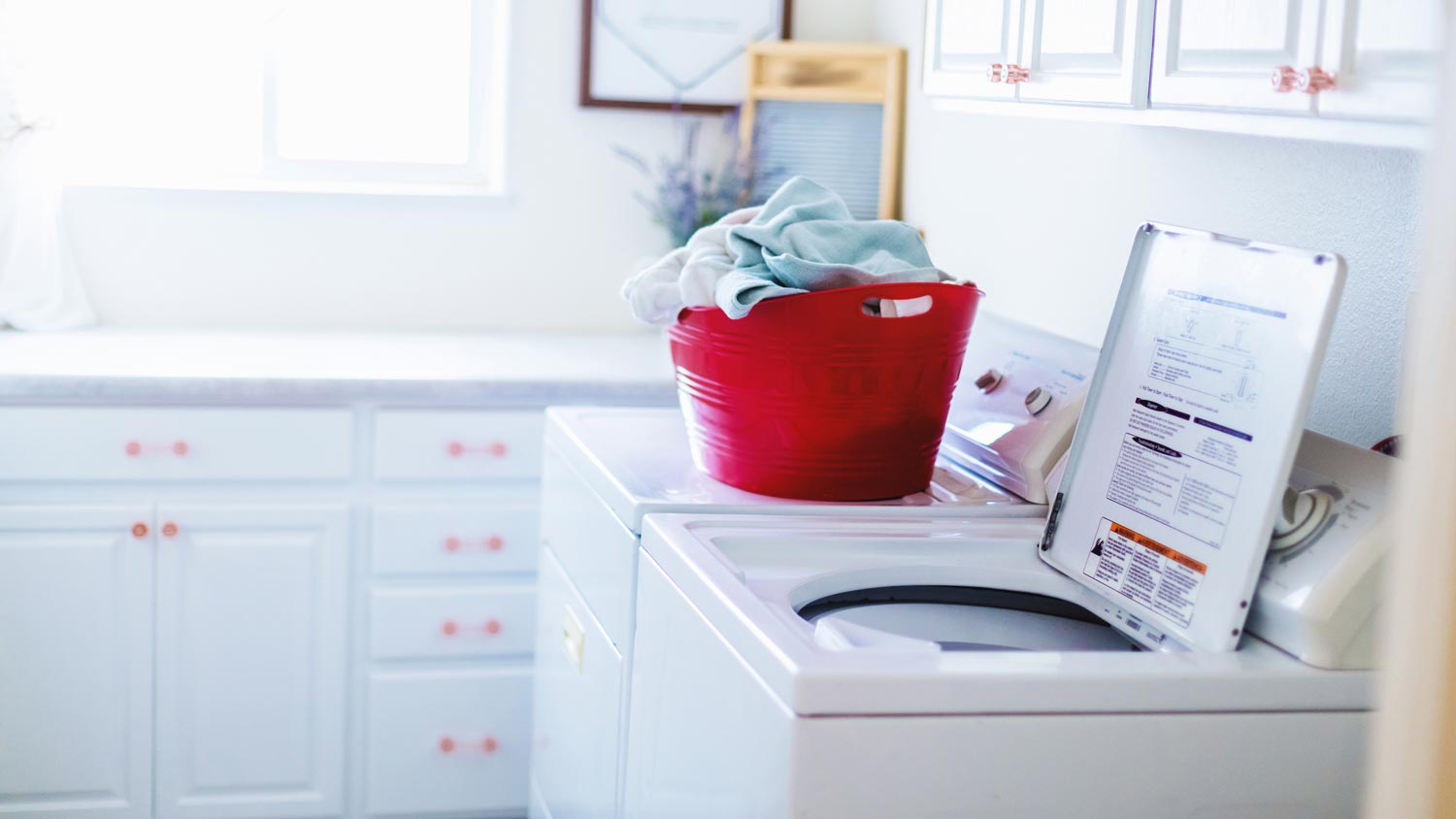 A bright laundry room with a top load washing machine