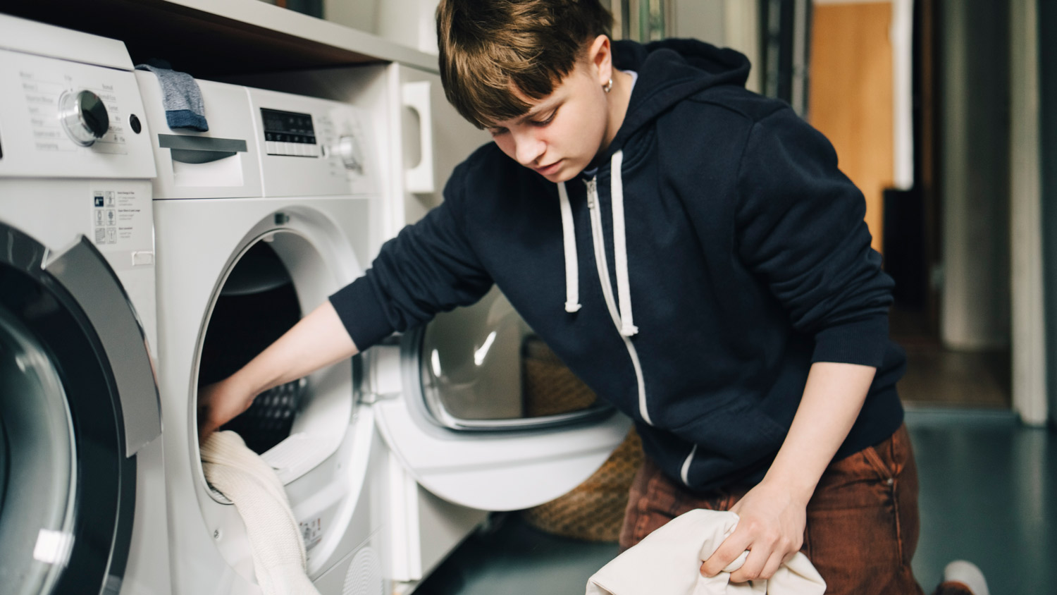 A laundry room with white cabinets