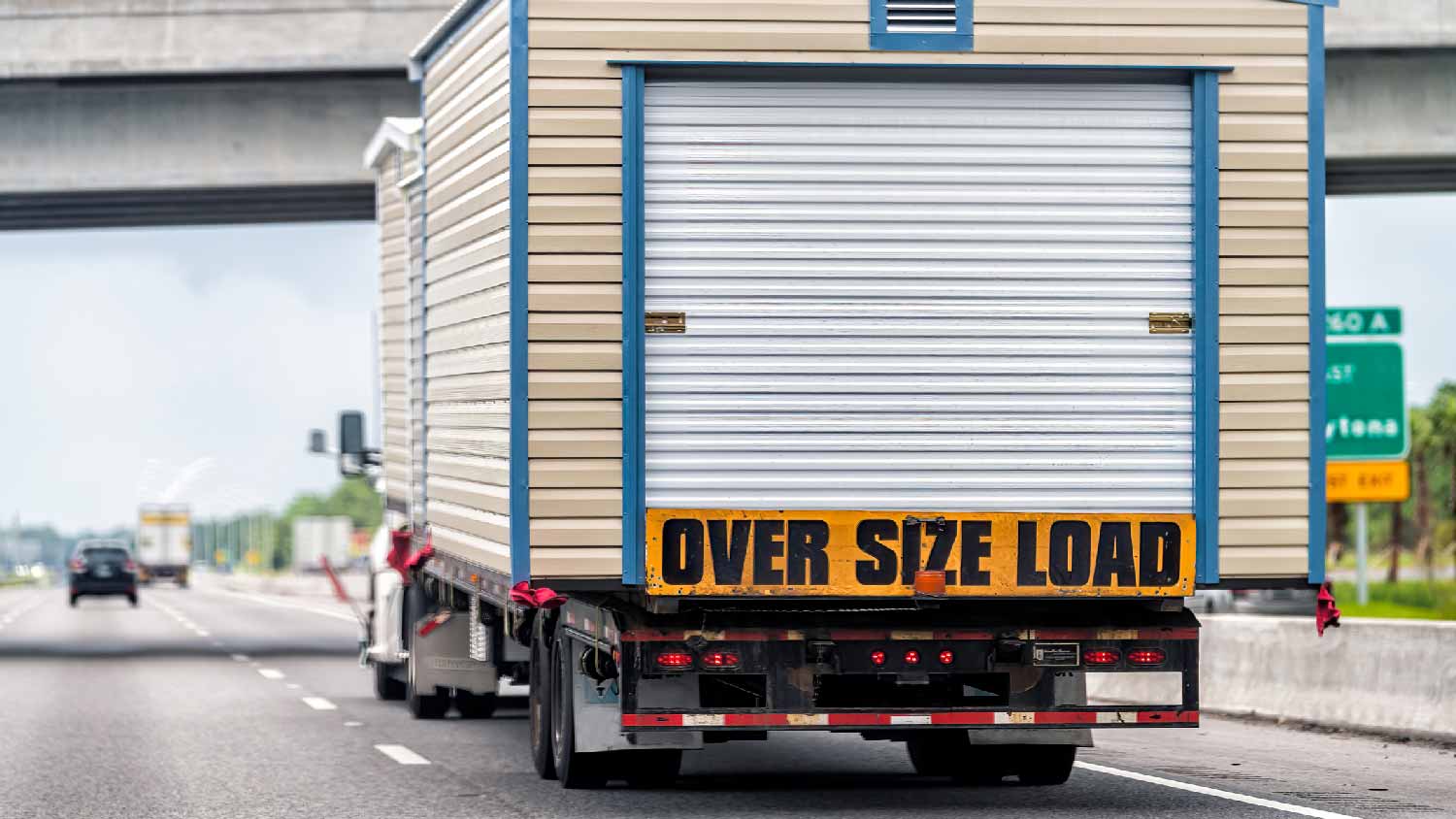  A truck on the highway hauling a shed