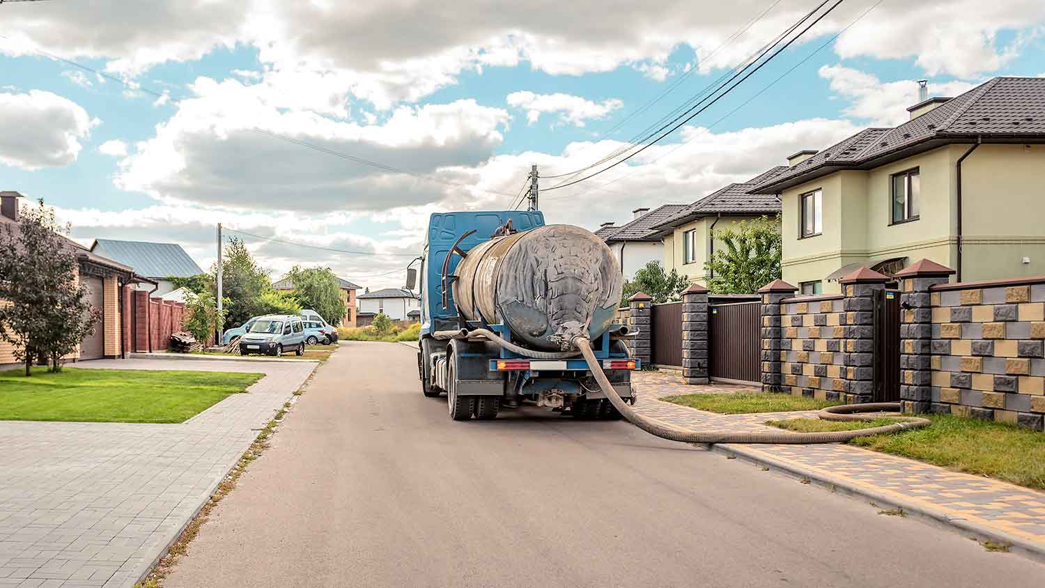 Truck parked outside of a house pumping a septic system