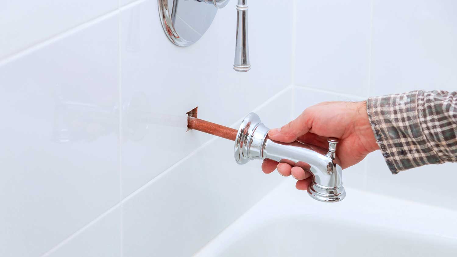 Plumber removing bathtub spout