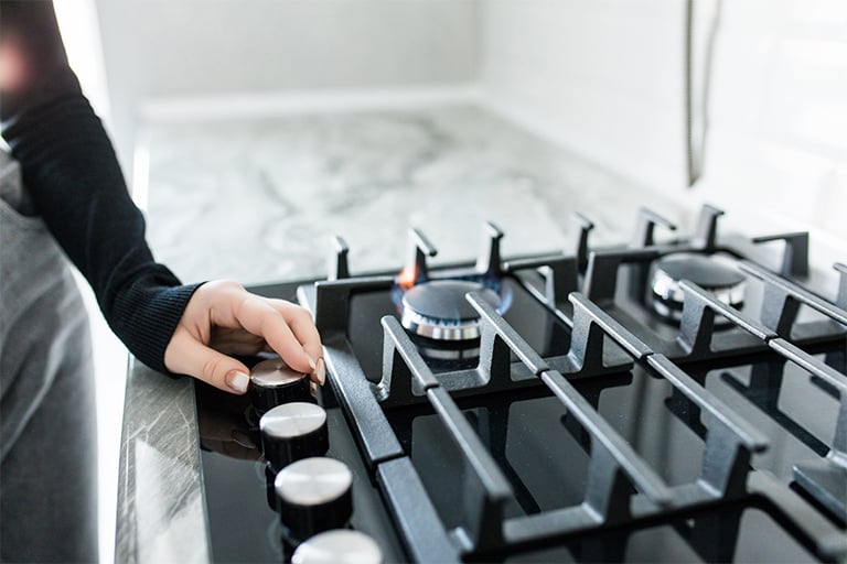 Woman turning off gas range