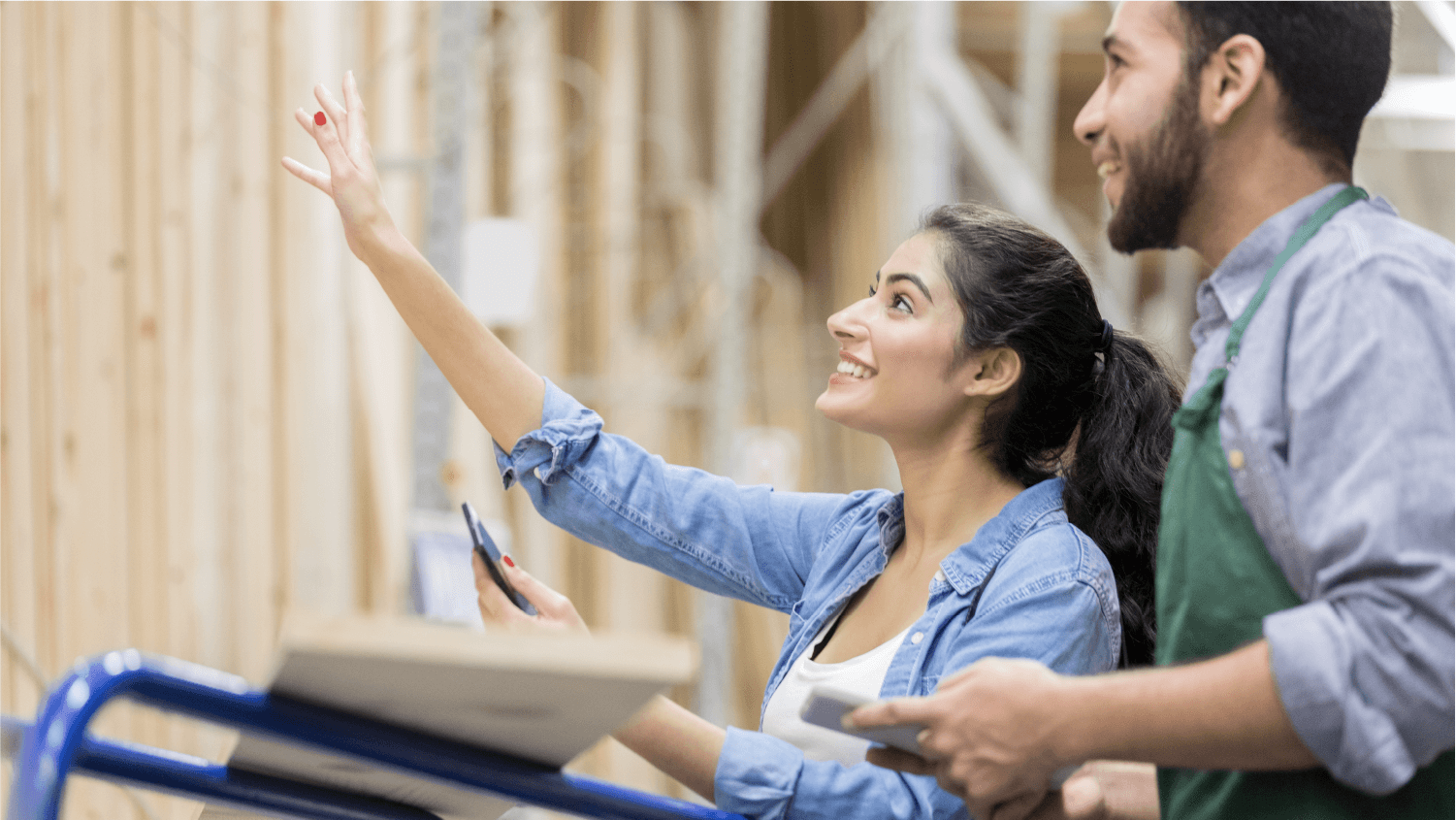 woman looking at lumber with worker at hardware store