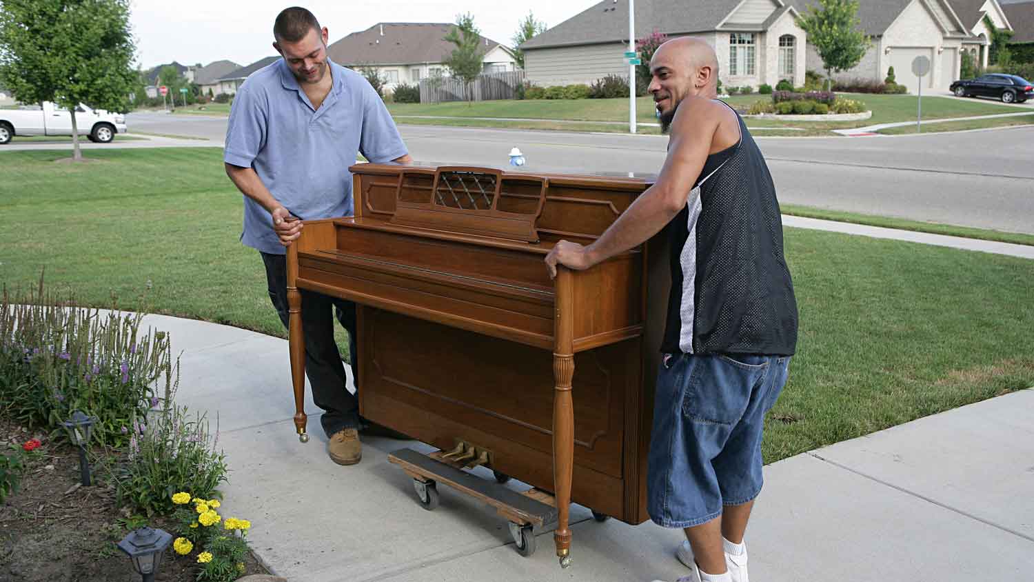 Two people moving a piano