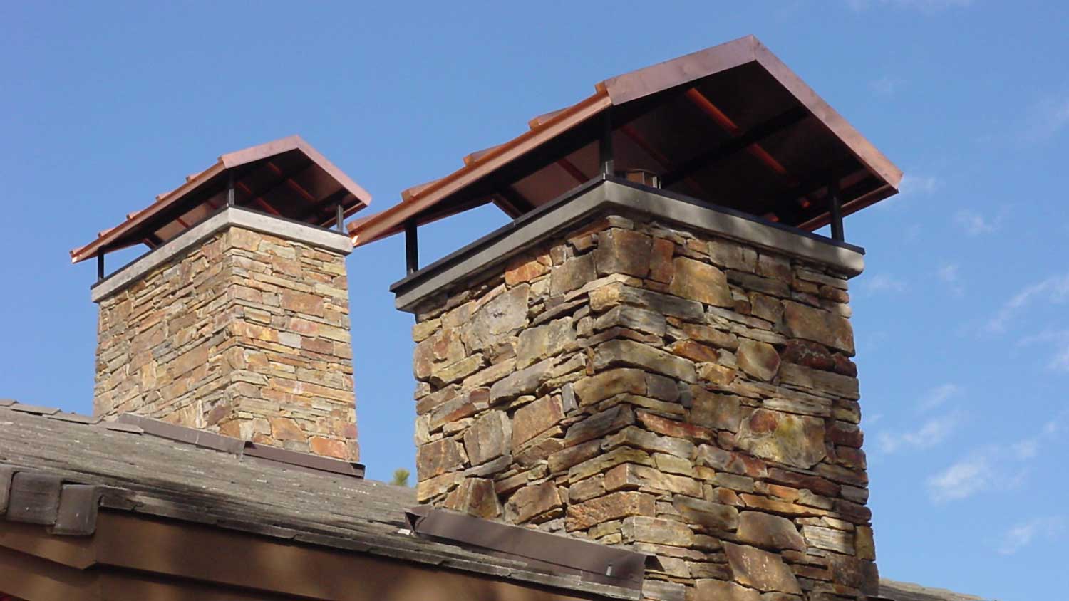 Two stone chimneys with chimney caps