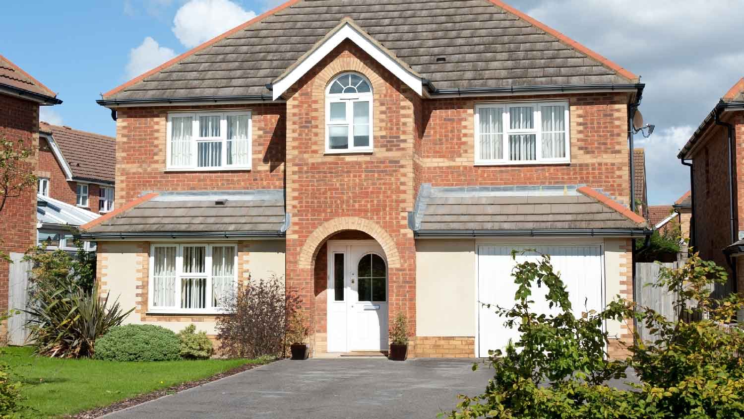 A two story house with an asphalt driveway