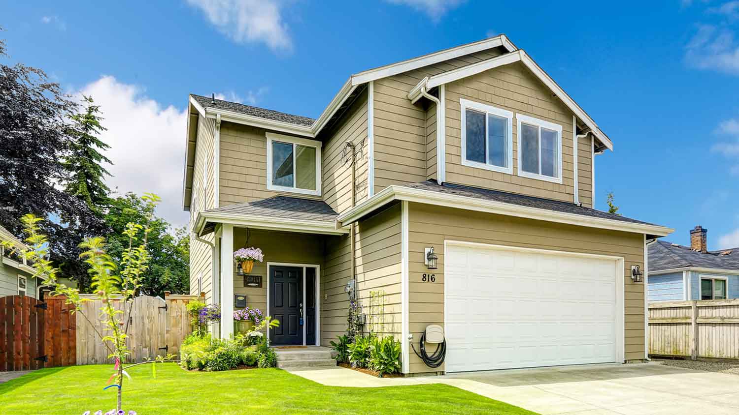 Two-story house with wood siding and a white garage door
