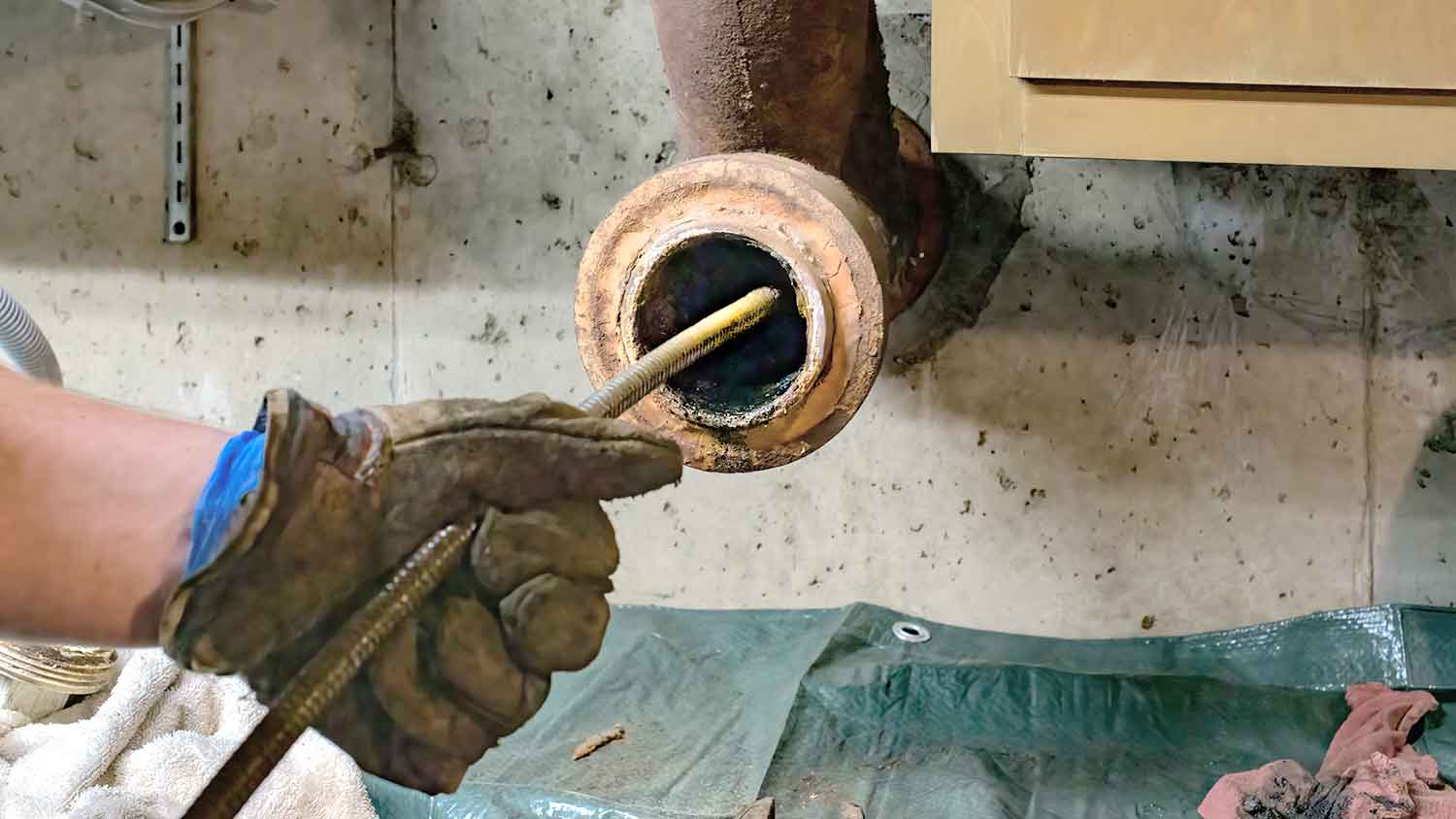 Plumber unclogging sewer main line