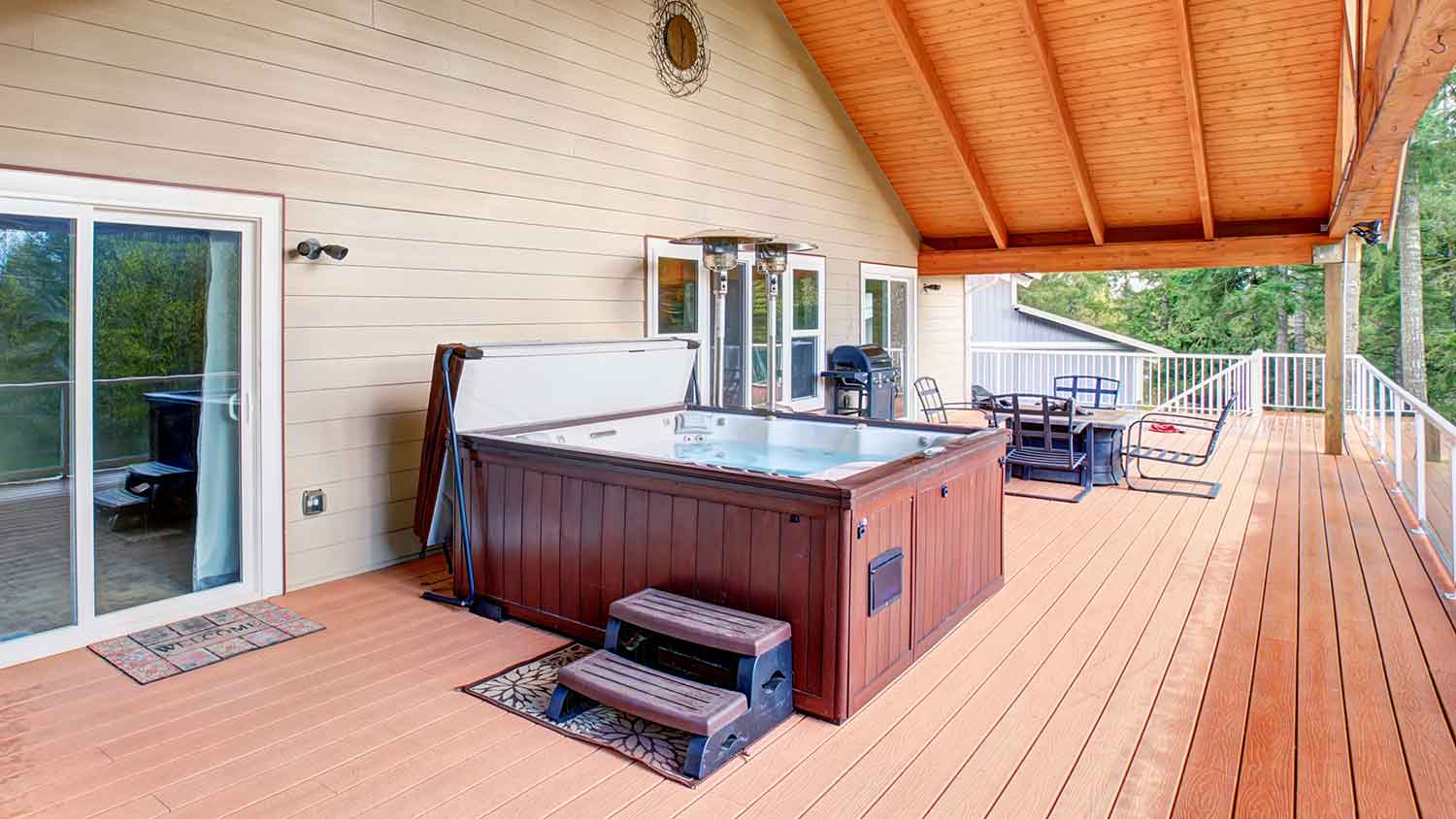 Hot tub with undermount cover lifter sitting on a large deck