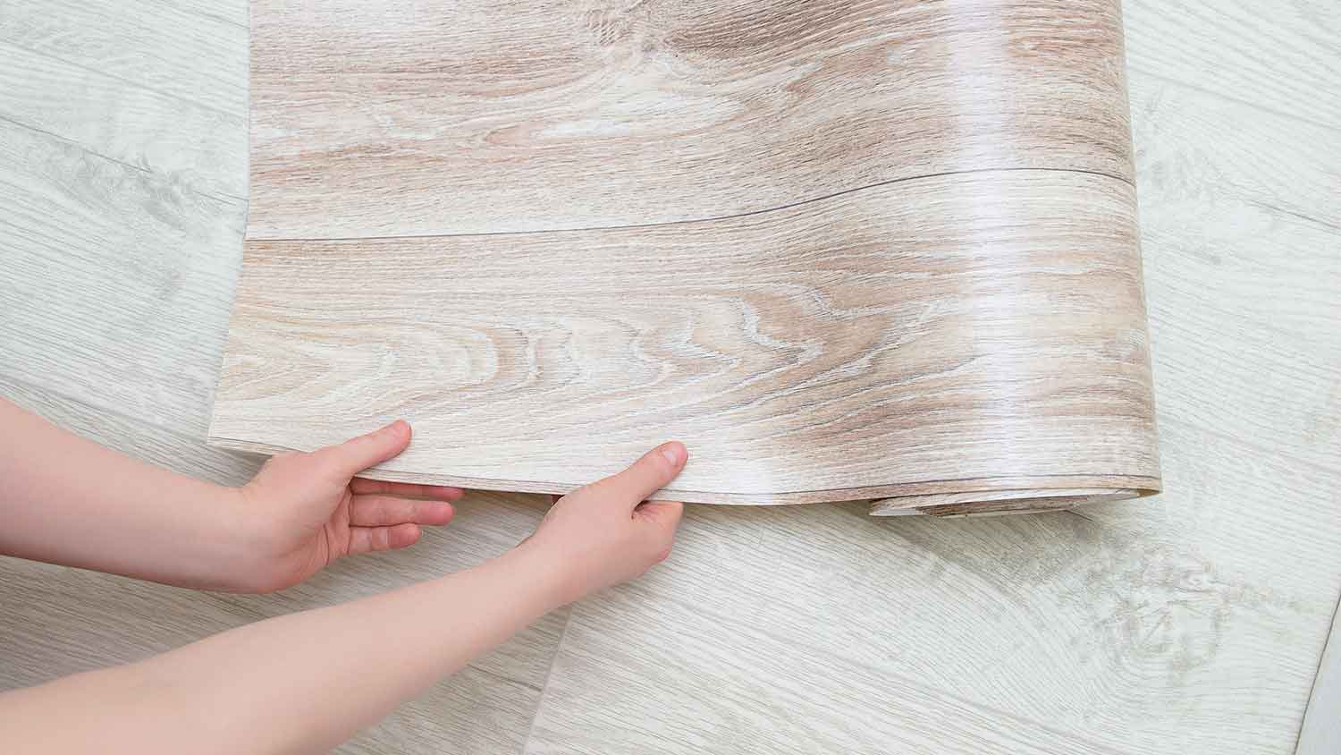 Woman unrolling sheet vinyl flooring