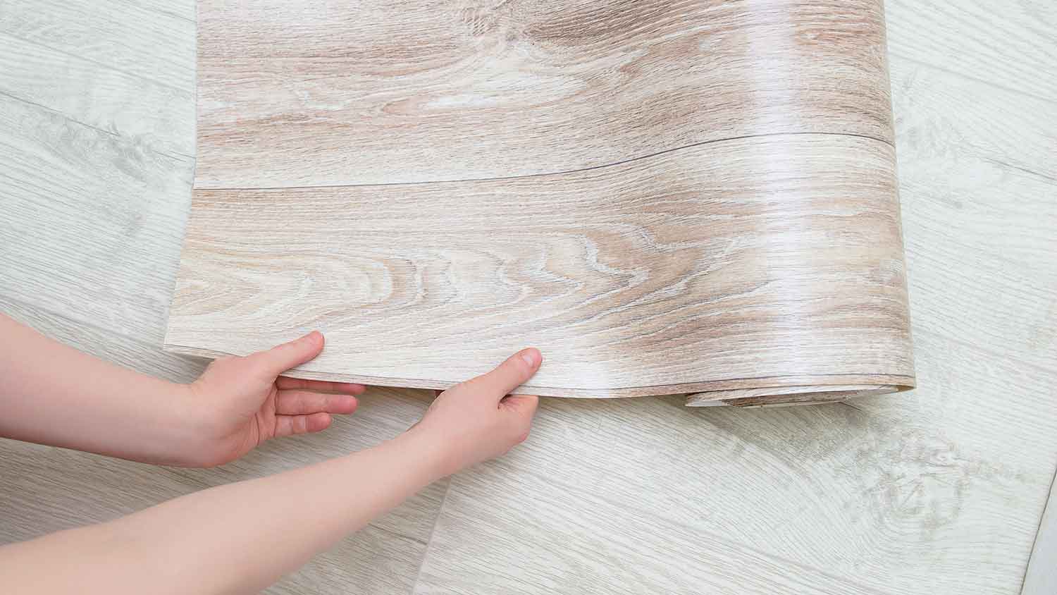 Woman unrolling sheet vinyl flooring  