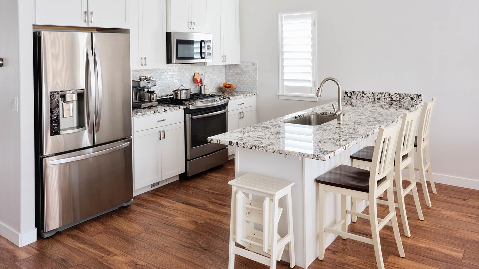 Interior of an American residential kitchen with marble countertops and modern appliances